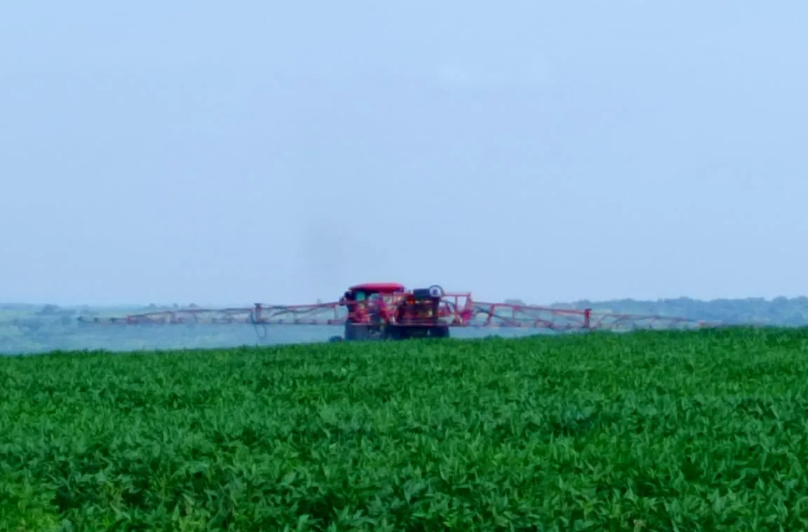 A boom sprayer tending a lush green soya bean field at Normah Agro Farm.